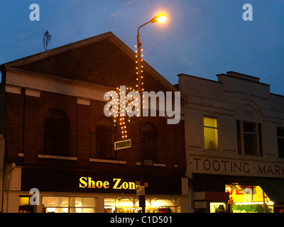 Tooting London England High Street bei Nacht In The Rain Eid Lichter geformt als A Palm Tree On A Lampost von Tooting Markt Stockfoto