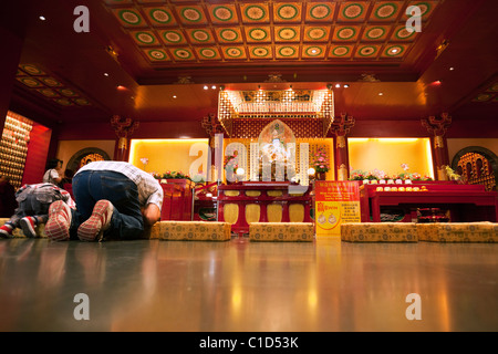 Anbeter Verbeugung in einem Schrein in der Buddha Tooth Relic Temple und Museum, Chinatown, Singapur Stockfoto