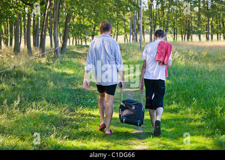 Mann und der junge mit einer schweren Tasche zusammen. Stockfoto