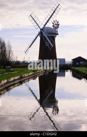 Windmühle Windpumpe in einem Deich in den Norfolk Broads reflektiert. Horsey, Norfolk, England, Großbritannien Stockfoto