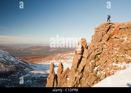 Ein Bergsteiger auf einem felsigen Granit Felsvorsprung oberhalb Coire eine Lochain in Cairngorm Mountains, Schottland, Großbritannien. Stockfoto