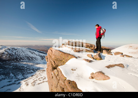 Ein Bergsteiger auf einem felsigen Granit Felsvorsprung oberhalb Coire eine Lochain in Cairngorm Mountains, Schottland, Großbritannien. Stockfoto