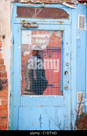 Ein Mann geht vorbei an einer Tür auf einer verlassenen abgerissen-Shop in Loughborough, Leicestershire, UK. Stockfoto