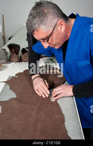 Qualifizierte Leder Herstellung Arbeiter schneiden einige Proben Stockfoto