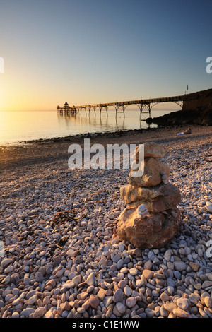 Clevedon Pier, Somerset, mit einem Stein Stapeln im Vordergrund, während die "Goldene Stunde" vor Sonnenuntergang. Stockfoto