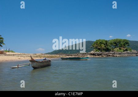 Madagaskar Insel Nosy Komba (neben Nosy Be) Fischen Dorf von Ampangoriana. Typisches Auslegerboot am Meeresstrand. Stockfoto
