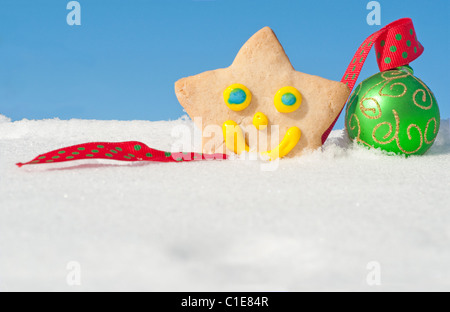 Ein herrlich Weihnachtsplätzchen auf Schnee mit einem grünen Weihnachtskugel mit Textfreiraum Stockfoto