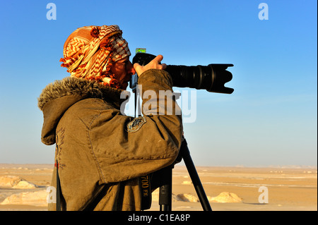 Frau Fotograf fotografiere Sanddünen mit einer Kamera auf einem Stativ in der Weissen Wüste National Park, westlich von Ägypten Stockfoto