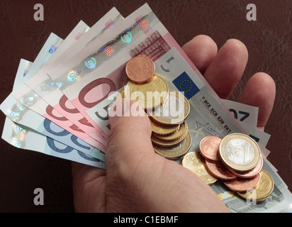 Handvoll der Euro-Euro-Banknoten und Euro-Münzen. Stockfoto