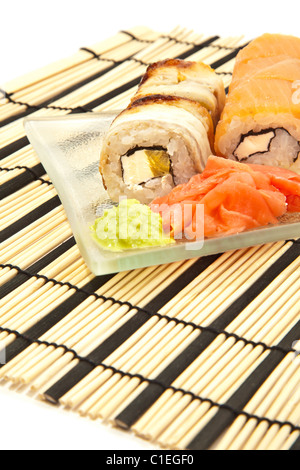 Maki Sushi mit Wasabi auf Sushi Bambusmatte isoliert Stockfoto