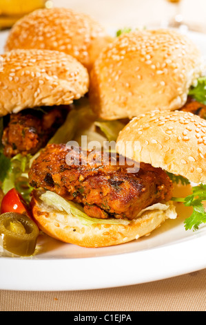 vier frische und köstliche Mini-Chicken Burger auf einem Teller, Nahaufnahme Stockfoto