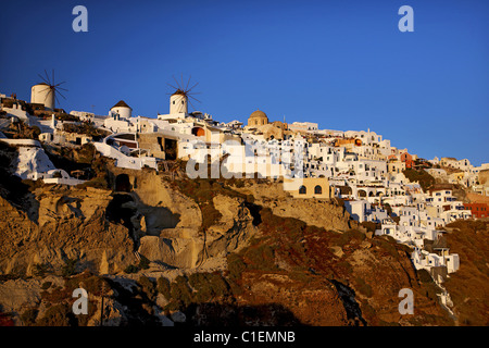 Blick auf den östlichen Teil des Dorf Oia mit seiner berühmten Windmühlen bei Sonnenuntergang. Santorin, Kykladen, Griechenland Stockfoto