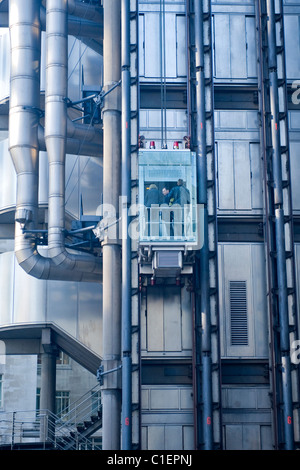 City of London bekleideten Menschen im außen Lift auf Lloyds Ikone modernen oder zeitgenössischen Metall futuristische Wolkenkratzer Büros Stockfoto