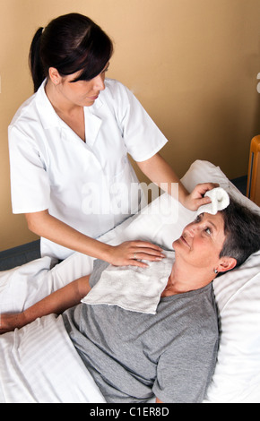 Eine Krankenschwester wäscht ein patient Stockfoto