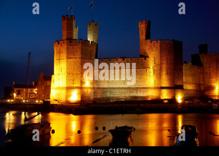 Caernarfon Castle wider in River Seiont, in der Abenddämmerung, Caernarfon, Wales, Vereinigtes Königreich Stockfoto