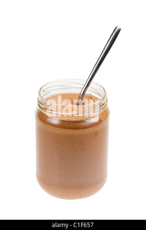 Glas Erdnussbutter mit Löffel isoliert auf weißem Hintergrund Stockfoto