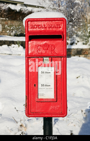 North Wales, UK, Großbritannien. Vorderansicht des einen traditionellen roten Briefkasten im Schnee Stockfoto