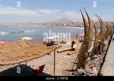 Huanchaco Beach in der Nähe von Trujillo, Peru, mit Caballitos de Totora und Urlauber Stockfoto