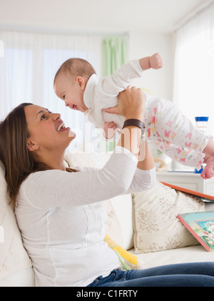 Lächelnde Mutter Baby heben Stockfoto