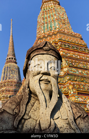 Statue des bärtigen Mannes vor bunten Stupas im Wat Pho in Bangkok, Thailand, Südostasien Stockfoto