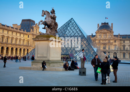 Statue von Louis XIV (Sonnenkönig) und Crystal Piramid vor dem Louvre-Museum. Paris, Frankreich. Stockfoto