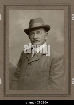 Originelles und sehr scharfes Studio-Porträt aus der Zeit des 1. Weltkriegs: Ein klug gekleideter reifer Mann, der selbstbewusst der Kamera zusieht, ein modischer Gentleman, der einen Homburg-Hut, Tweed-Anzug, Kragen und Kragen trug. Die Mode für Kragen wurde während des 1. Weltkriegs schmaler – datiert vom 2. Juni 1917 auf der Rückseite, Bexhill-on-Sea, nahe Hastings und Eastbourne, Sussex, Großbritannien Stockfoto