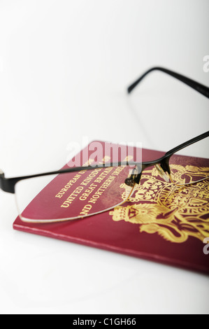 Stock Foto eines britischen Passes auf weißem Hintergrund mit einer Brille. Stockfoto