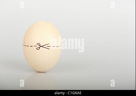 Stock Foto eines Eies mit einer gepunkteten Linie um ihn herum und Schere eine sehr offensichtliche Schnitte hier Erklärung angibt. Stockfoto