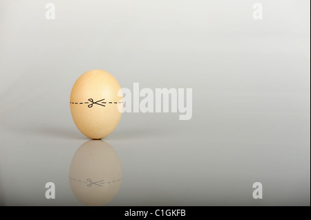 Stock Foto eines Eies mit einer gepunkteten Linie um ihn herum und Schere eine sehr offensichtliche Schnitte hier Erklärung angibt. Stockfoto