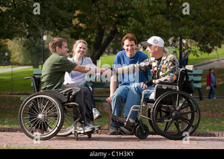 Veteranen Freunde beitreten und Händeschütteln im park Stockfoto