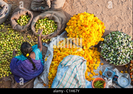 Indische Frau verkaufte Gemüse und Blumen auf einer Straße Gemüsemarkt in Puttaparthi, Andhra Pradesh, Indien Stockfoto