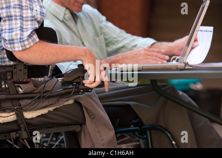 Geschäftsleute im Rollstuhl an einem Notebook arbeitet Stockfoto