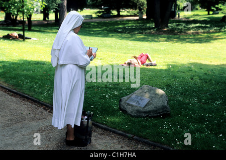 Frankreich, Paris, Dichter Garten, Nonne, die ein Gedicht auf einem Stein Stockfoto