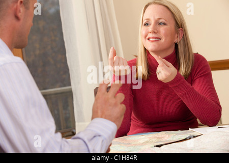 Unterzeichnung des Satzes "Was möchten Sie tun" in amerikanischer Gebärdensprache während der Kommunikation mit einem Mann Frau Stockfoto