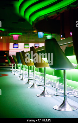 Stühle in Zeile in Bar mit grüne Lichter Stockfoto