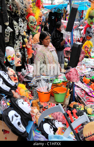 Aymara-Frau verkauft Masken (einschließlich Ghostface Masken aus den Scream-Filmen), Kostüme und Gegenstände für Halloween auf dem Straßenmarkt in La Paz, Bolivien Stockfoto