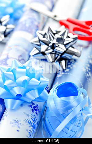 Rollen Weihnachten Geschenkpapier mit Bändern, Schleifen und Schere Stockfoto