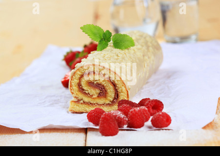 Biskuitrolle mit weißer Schokolade Zuckerguss glasiert Stockfoto