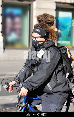 Nahaufnahme Radfahrerin trägt Gesichtsmaske gegen Verkehrsauspuff Dämpfe auf dem Fahrrad im Winter London England Großbritannien Stockfoto