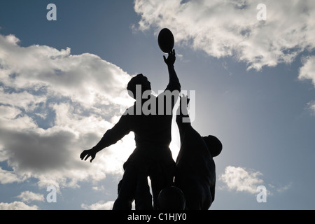 Rückwärtiger Blick auf die Bronzeskulptur von Gerald Laing, die eine Rugby-Linie zeigt, vor dem Allianz Stadium, Twickenham, London, Großbritannien. Stockfoto