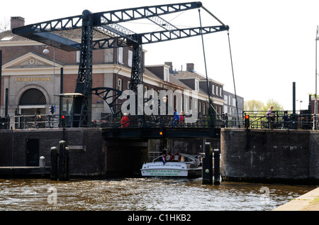 Ein Boot unter die Brücke über den Kanal in Amsterdam Stockfoto