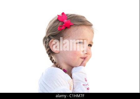 Ein kleines dreijähriges Mädchen auf einen weißen Hintergrund an etwas zu denken. Stockfoto