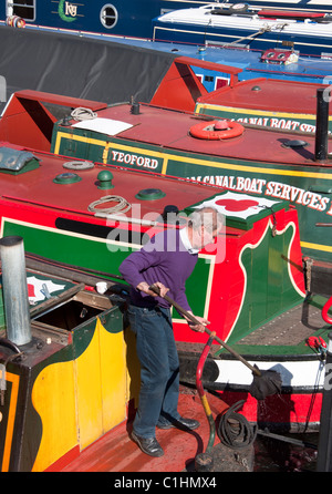 Ein Mann auf einem der bunten langen Boote auf Gas Street Basin im Zentrum von Birmingham, England. Stockfoto