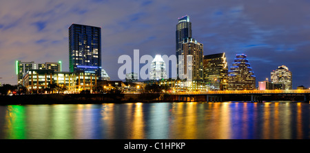 AUSTIN, Texas - Panorama der Austin's Skyline der Stadt in der Dämmerung, wenn die Lichter sich auf dem Wasser und die Congress Street Brücke rechts widerspiegelt. Stockfoto