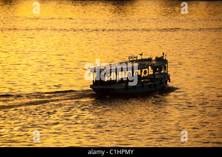 Einem traditionellen ägyptischen Feluke Boot segelt auf dem Nil in Luxor, Ägypten mit einer Personenfähre vorbei. Stockfoto