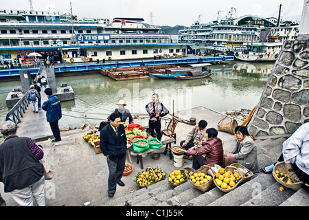 CHINA, SANDOUPING: Chinesische Männer und Frauen mit Obst von Körben und frisch gerösteten Nüssen und Samen für Touristen. Stockfoto