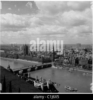 1960er Jahre, Luftaufnahme auf die Themse, London und die umliegende Landschaft mit Westminster Bridge und dem Victoria Tower am Palace of Westminster. Stockfoto