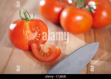 Frische Tomaten auf ein Schneidebrett mit Messer. Stockfoto