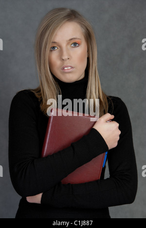 Bildnis einer blonden Frau in ein schwarzes t-Shirt mit einem roten notebook Stockfoto