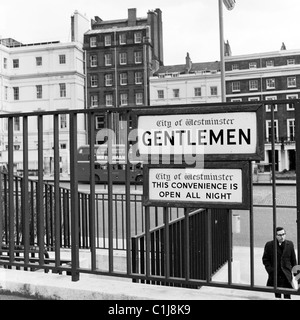 London, 1960er Jahre, ein Schild auf einem Treppengeländer, das eine öffentliche Toilette für Herren in der City of Westminster anzeigt, ein Komfort, der die ganze Nacht geöffnet ist. Stockfoto